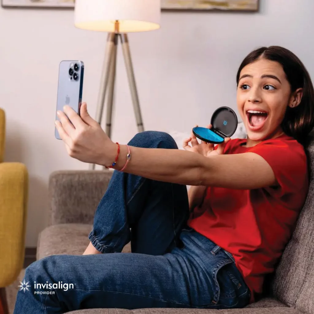 teenage posing for selfie with invisalign box