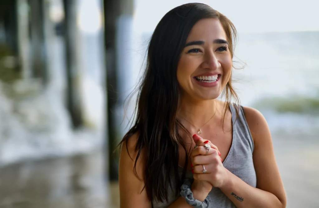 woman smiling at beach under pier